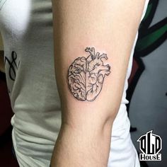 a woman's arm with a heart shaped tattoo on the left side of her arm