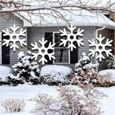 snowflakes on the side of a house in front of shrubbery and bushes