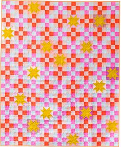 an orange and pink checkered quilt with stars on the top, in front of a white background