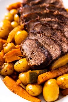 a white plate topped with meat, potatoes and carrots