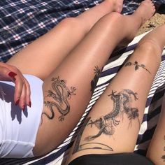 two women with dragon tattoos on their legs