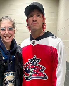 a man and woman standing next to each other in front of a locker room wall