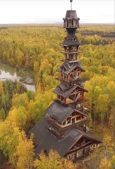 an aerial view of a tall tower in the middle of a forest with trees surrounding it