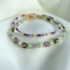 Beautiful Dainty flower bracelet, it comes with a matching bracelet(stretchy). Purple Beaded Bracelets Bestie, Purple And Green Bracelet, Green Beaded Bracelets, Lover Jewelry, Daisy Bracelet, Brown Bracelet, Purple Bracelet, Bead Charms Diy, Purple Jewelry