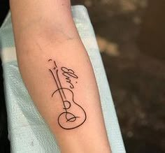 a person with a guitar tattoo on their left arm and the word love written in cursive writing