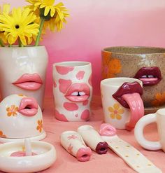 various vases and cups with lipstick painted on them