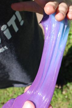 a person holding a purple toothbrush in their left hand and the other hand is pointing at it