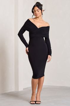 a woman wearing a black dress with long sleeves and an asymmetrical neckline