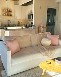 a living room filled with furniture next to a kitchen