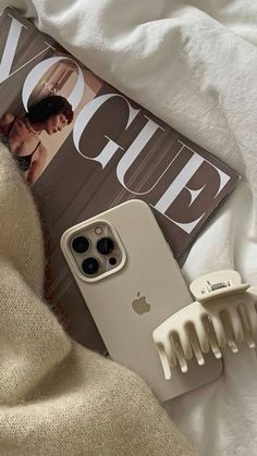 an iphone case sitting on top of a magazine next to a hairbrush and comb