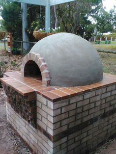 an outdoor brick pizza oven built into the ground