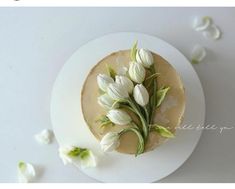 a white plate topped with a cake covered in frosting and flowers on top of it