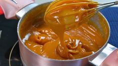 a metal pot filled with sauce on top of a stove