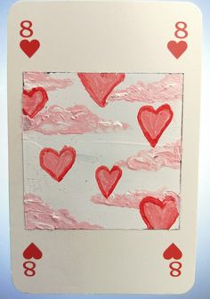 a card with hearts drawn on it and some clouds in the sky behind it,