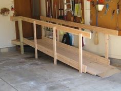 there is a bench made out of plywood and some tools hanging on the wall