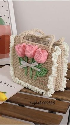 a crocheted purse with pink flowers on it