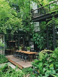 an outdoor dining area surrounded by trees and greenery is seen in this image from the backyard