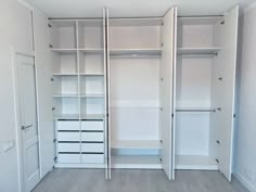 an empty closet with white shelves and drawers