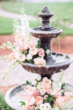 two tiered water fountain with flowers and greenery