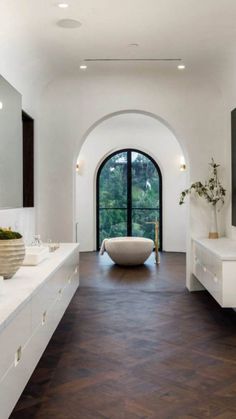 a large bathroom with an arched doorway leading to the outside