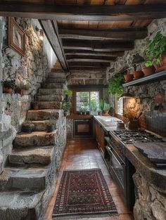 a kitchen with stone walls and stairs leading up to the second floor