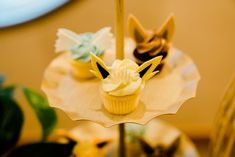 three cupcakes on top of each other with icing and decorations in the shape of animals