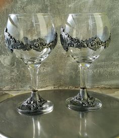 two wine glasses sitting on top of a metal tray