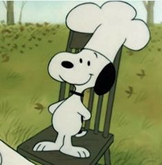 a cartoon dog sitting in a chair with a chef's hat on