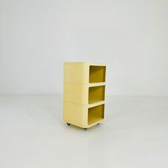 a yellow shelf sitting on top of a white floor