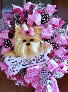 a pink and black wreath with a dog on it that says live laugh bark in front of the door