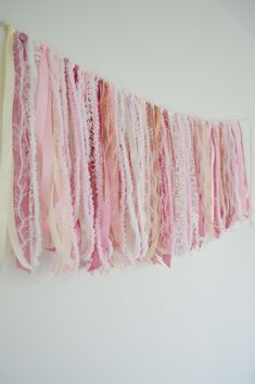 there is a wall hanging made out of different types of yarns and fabric strips