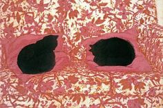 two black cats sitting in the middle of a pink and gold patterned bed spread with leaves on it