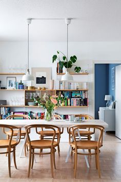 a dining room table and chairs with bookshelves in the backgroung