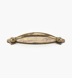 an antique brass drawer handle on a white background