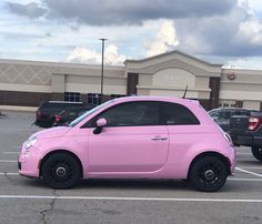 a pink car is parked in a parking lot