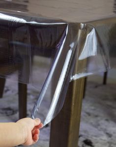 a baby reaching for a plastic table cover