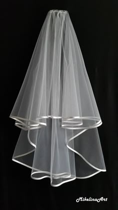 two tiered wedding veils with white ribbon on black background for use as decoration