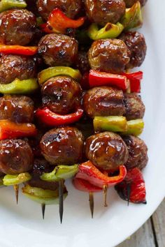 skewered sausages and peppers on a white plate