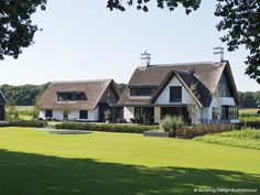 a large house with grass and trees in the foreground