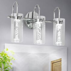 three light bathroom fixture with clear glass cylinder shades and chrome finish, in a modern style