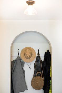 a coat rack with hats, coats and purses hanging on it's hooks