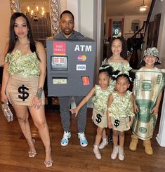 a group of people standing next to each other in front of a machine with money on it