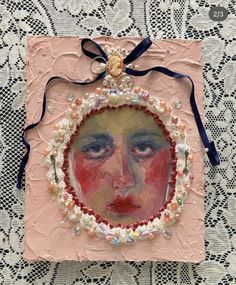 an altered portrait is displayed on a doily