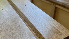 a close up view of the top of a wooden table with drawers in the background