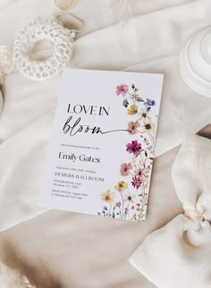 a baby in bloom book laying on top of a bed next to a lace doily