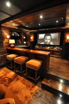 a home bar with stools in front of it and a screen on the wall