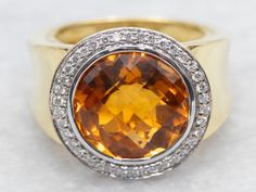 Add a touch of elegance to any outfit with this ring. Crafted with a round-cut citrine and a shimmering diamond halo, this ring is the perfect blend of sophistication and modern style. Elevate your jewelry collection with this stunning piece! Metal: 18K Yellow and White Gold Gem: Citrine 5.65 Carats Gem Measurements: 12.6 mm, Round Accents: Diamonds totaling .25 Carats, SI in Clarity, G in Color Ring Size: 6.50 Marks: "18K(C)KRISTINA" Stamped on the inside band SKU #: A51180 Each piece has been identified and graded by a Graduate Gemologist who has been certified by the Gemological Institute of America (GIA). We have six brick-and-mortar storefronts in Maine, Massachusetts, and New Hampshire and have been in business for over 25 years! Please visit our Shop's About Page or our website for Halo Halo, Ring Halo, Diamond Halo Ring, Citrine Ring, November Birthstone, Halo Diamond Ring, Color Ring, Halo Rings, Halo Ring