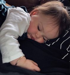 a small child sleeping on top of a woman's lap