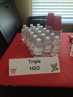 bottles of water are on a table with a sign that says triple h2o