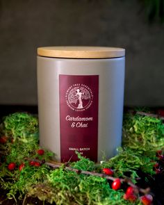 the candle is surrounded by moss and red berries